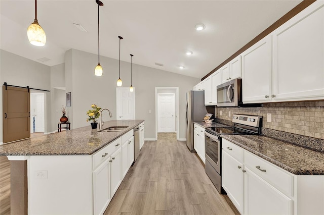 6376 SW 117th Street Rd, Ocala, FL 34476 - kitchen featuring appliances with stainless steel finishes, vaulted ceiling, backsplash, light wood-style floors, and a barn door