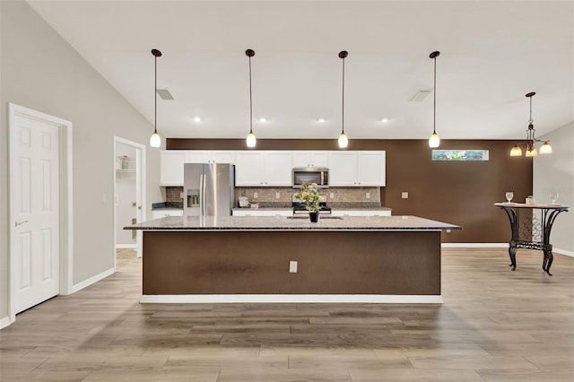 6376 SW 117th Street Rd, Ocala, FL 34476 - kitchen featuring appliances with stainless steel finishes, white cabinets, a large island with sink, decorative backsplash, and light wood-style floors