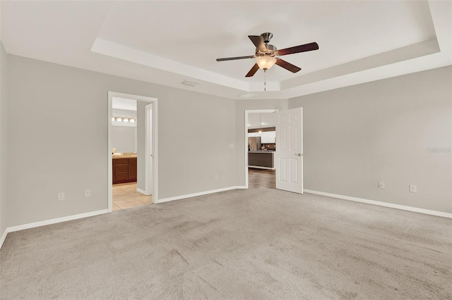 6376 SW 117th Street Rd, Ocala, FL 34476 - unfurnished bedroom featuring a tray ceiling, light carpet, ensuite bathroom, and ceiling fan