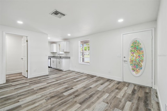 foyer entrance with light wood finished floors, recessed lighting, and baseboards