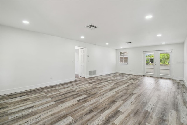 unfurnished room with recessed lighting, light wood-type flooring, baseboards, and french doors
