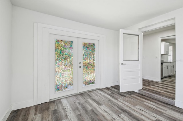 empty room with wood finished floors, baseboards, and french doors