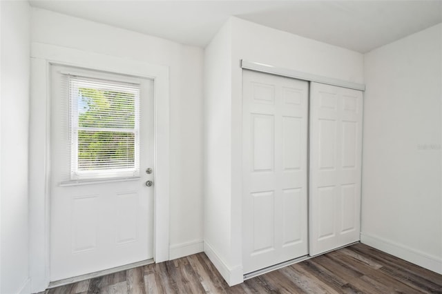 doorway to outside with dark wood-style flooring and baseboards