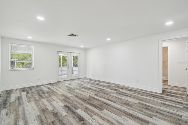 spare room with french doors, light wood-style floors, recessed lighting, and baseboards