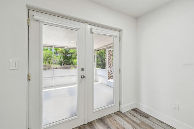 doorway to outside featuring light wood-type flooring, french doors, and baseboards