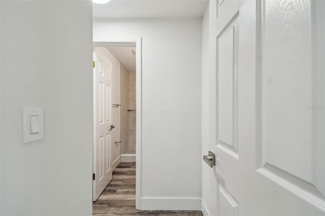 hall featuring wood finished floors and baseboards
