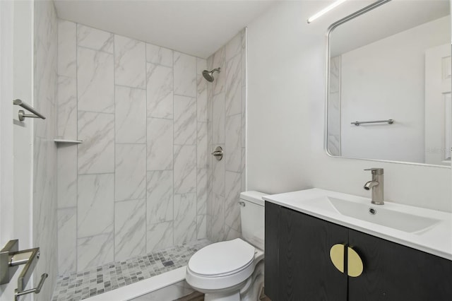 bathroom with toilet, a stall shower, and vanity
