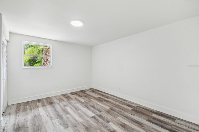 spare room featuring wood finished floors and baseboards