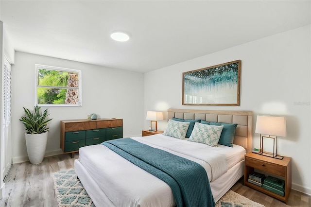 bedroom with light wood-style floors and baseboards