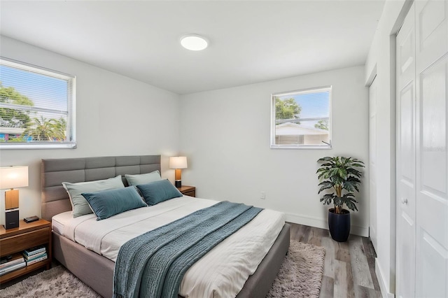 bedroom with wood finished floors and baseboards