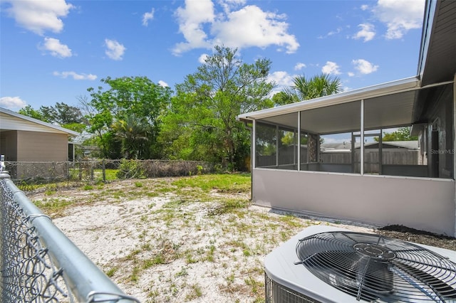 view of yard with central AC unit and a sunroom