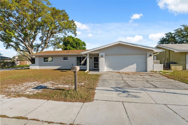 single story home with a garage, central AC unit, driveway, and brick siding