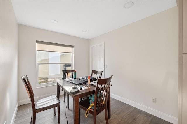 dining space featuring baseboards and dark wood-type flooring