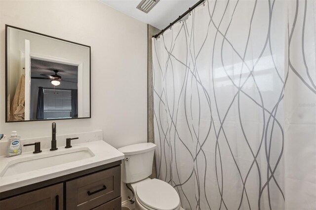 full bathroom with toilet, vanity, a ceiling fan, and curtained shower