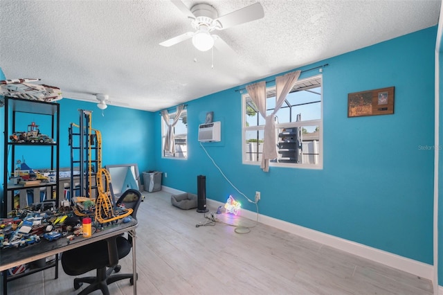 office space featuring a textured ceiling, wood finished floors, ceiling fan, and baseboards