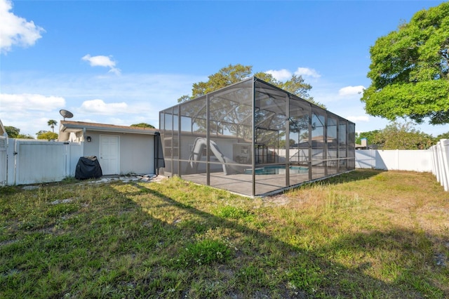 rear view of property with stucco siding, a patio, and glass enclosure