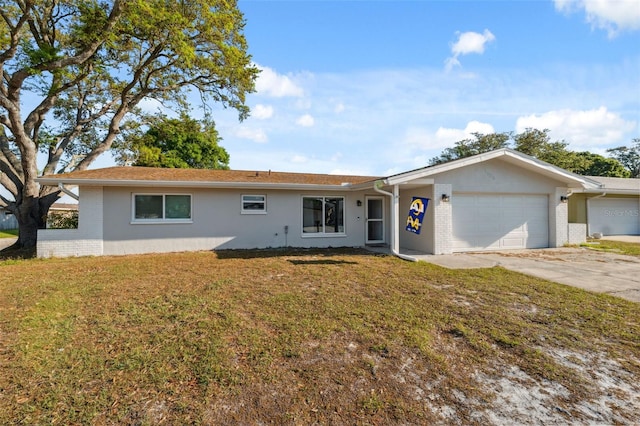 single story home featuring an attached garage, concrete driveway, a front lawn, brick siding, and stucco siding