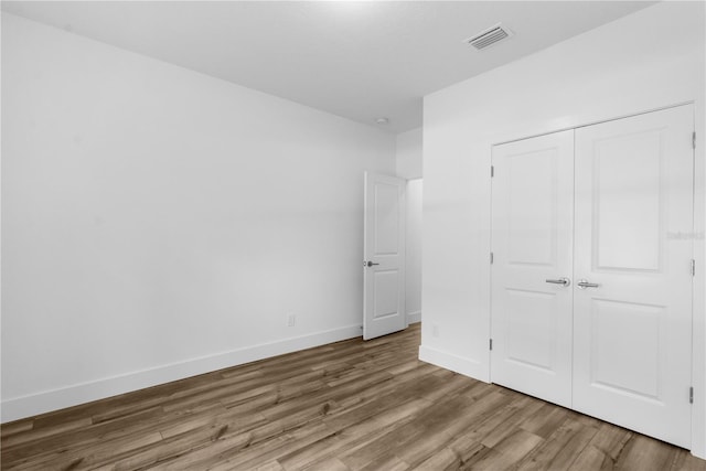 16247 Little Auk Rd, Weeki Wachee, FL 34614 - unfurnished bedroom with wood finished floors, baseboards, and a closet