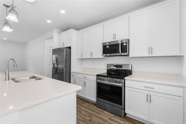16247 Little Auk Rd, Weeki Wachee, FL 34614 - kitchen featuring appliances with stainless steel finishes, a sink, light wood finished floors, white cabinetry, and light countertops