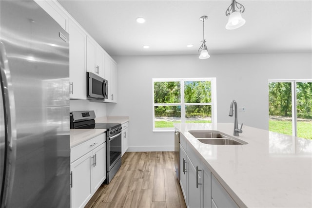 16247 Little Auk Rd, Weeki Wachee, FL 34614 - kitchen featuring appliances with stainless steel finishes, a sink, recessed lighting, light wood finished floors, and decorative light fixtures