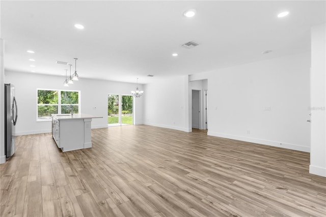16247 Little Auk Rd, Weeki Wachee, FL 34614 - unfurnished living room with a chandelier, light wood finished floors, recessed lighting, a sink, and baseboards