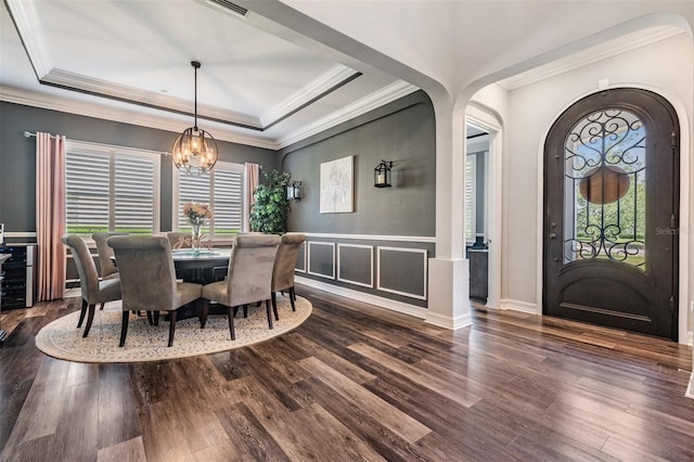 17724 Daisy Farm Dr, Lutz, FL 33559 - dining area with wood finished floors, arched walkways, a chandelier, a tray ceiling, and crown molding