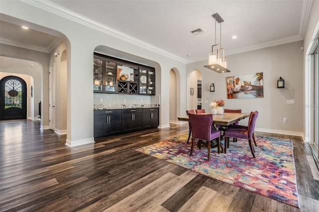17724 Daisy Farm Dr, Lutz, FL 33559 - dining room featuring dark wood-style flooring, wet bar, arched walkways, ornamental molding, and recessed lighting