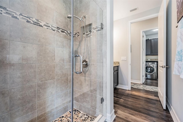 17724 Daisy Farm Dr, Lutz, FL 33559 - full bathroom with washer / clothes dryer, a stall shower, wood finished floors, and vanity