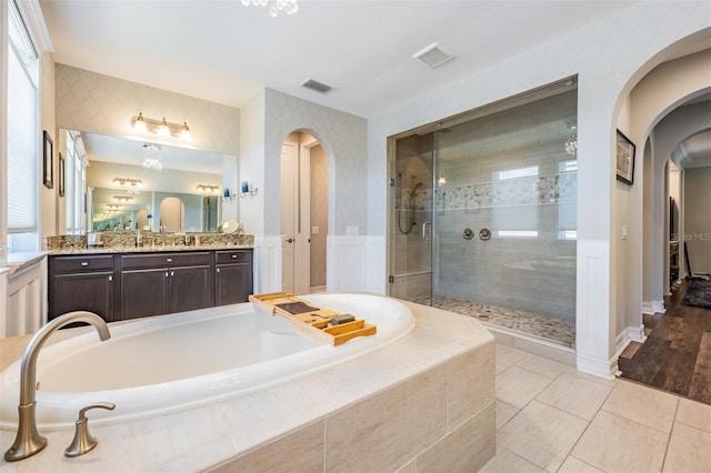 17724 Daisy Farm Dr, Lutz, FL 33559 - full bathroom featuring a bath, vanity, tiled shower, tile patterned floors, and a decorative wall