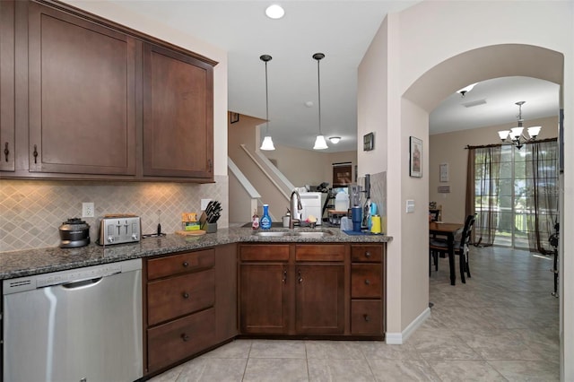 7001 Interbay Blvd Unit 242, Tampa, FL 33616 - kitchen featuring stainless steel dishwasher, a sink, a chandelier, decorative backsplash, and dark stone counters