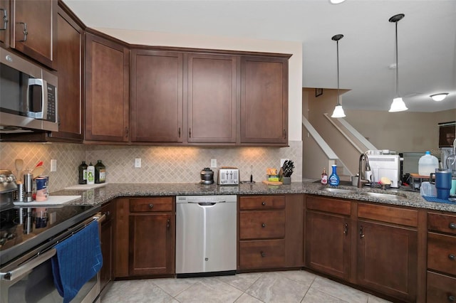 7001 Interbay Blvd Unit 242, Tampa, FL 33616 - kitchen with appliances with stainless steel finishes, a sink, dark stone counters, and tasteful backsplash
