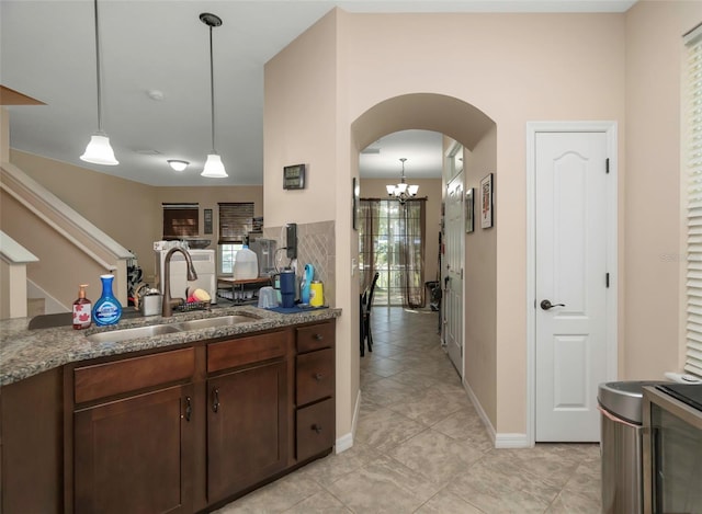 7001 Interbay Blvd Unit 242, Tampa, FL 33616 - kitchen featuring a sink, arched walkways, light tile patterned floors, and hanging light fixtures