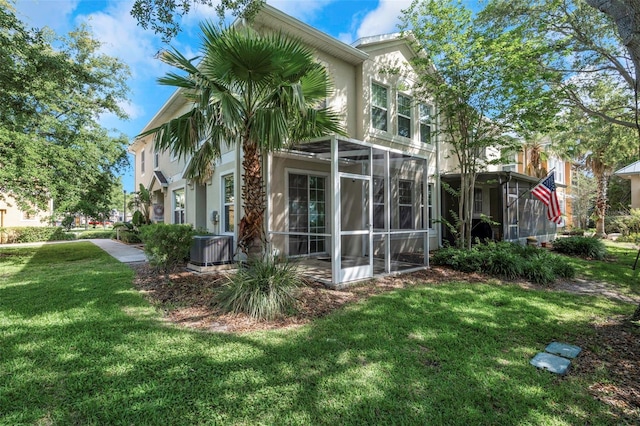 7001 Interbay Blvd Unit 242, Tampa, FL 33616 - rear view of property featuring stucco siding, a yard, cooling unit, and glass enclosure