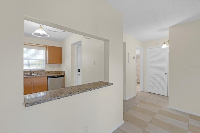 2820 Somerset Park Dr Unit 101, Tampa, FL 33613 - kitchen with dishwasher, a sink, baseboards, stone counters, and a textured ceiling