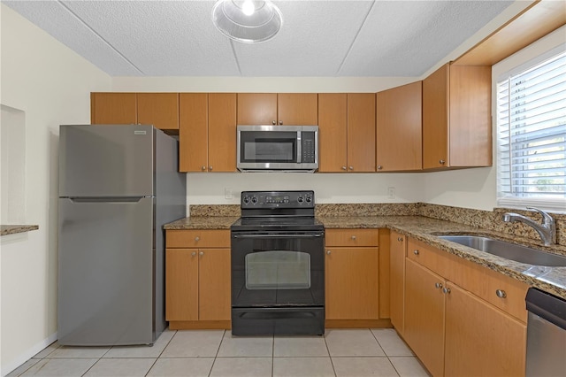 2820 Somerset Park Dr Unit 101, Tampa, FL 33613 - kitchen featuring stainless steel appliances, a sink, a textured ceiling, light stone counters, and light tile patterned floors