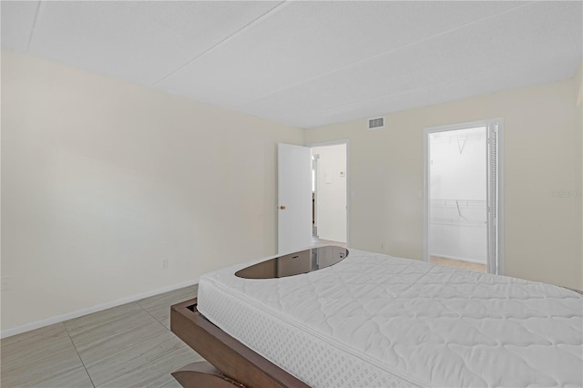 2820 Somerset Park Dr Unit 101, Tampa, FL 33613 - bedroom featuring baseboards, light tile patterned flooring, and a spacious closet