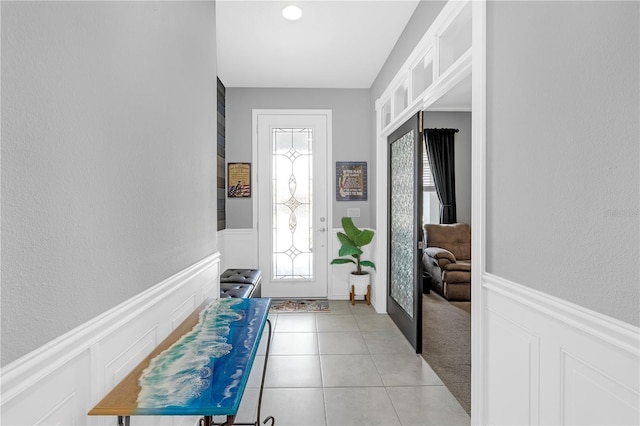 11684 Brighton Knoll Loop, Riverview, FL 33579 - doorway with a wainscoted wall, light tile patterned floors, and a textured wall