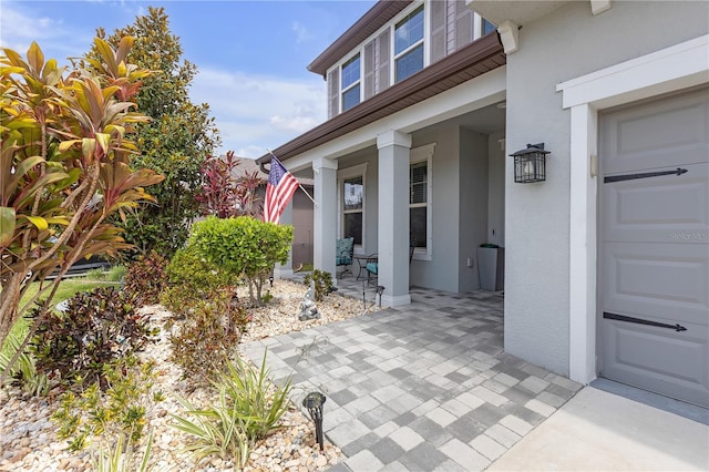 11684 Brighton Knoll Loop, Riverview, FL 33579 - property entrance with stucco siding, a garage, and a porch