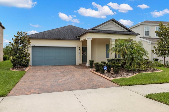3972 Wisdom Trl, Land O Lakes, FL 34638 - view of front facade featuring decorative driveway, stucco siding, a garage, a front yard, and a shingled roof