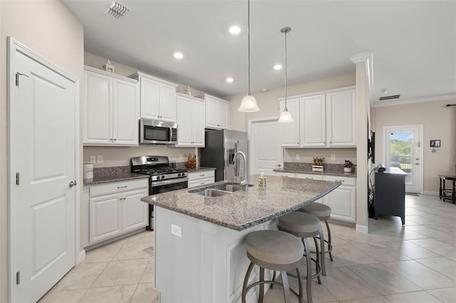 3972 Wisdom Trl, Land O Lakes, FL 34638 - kitchen featuring appliances with stainless steel finishes, a sink, light tile patterned flooring, a kitchen island with sink, and white cabinets