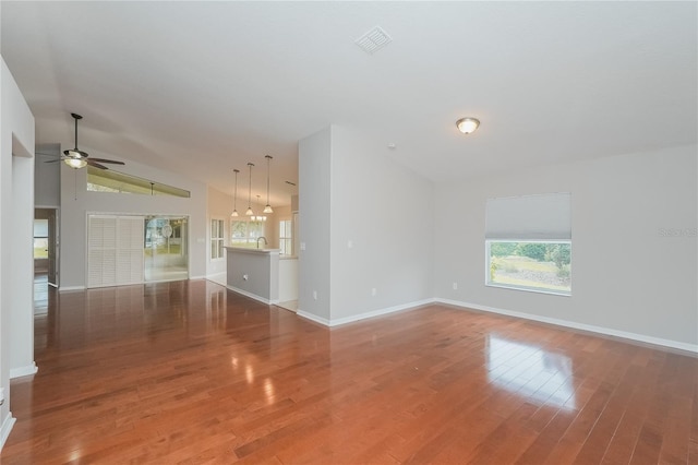 11741 Teapot Ct, Spring Hill, FL 34609 - unfurnished living room featuring a ceiling fan, lofted ceiling, baseboards, wood finished floors, and a sink