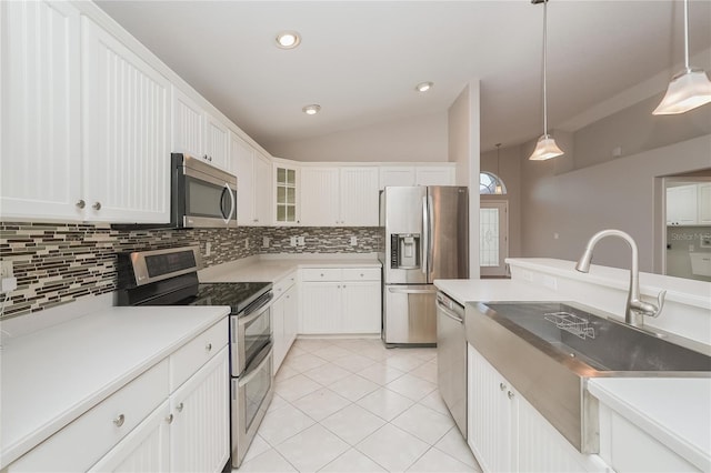 11741 Teapot Ct, Spring Hill, FL 34609 - kitchen with stainless steel appliances, a sink, backsplash, vaulted ceiling, and decorative light fixtures