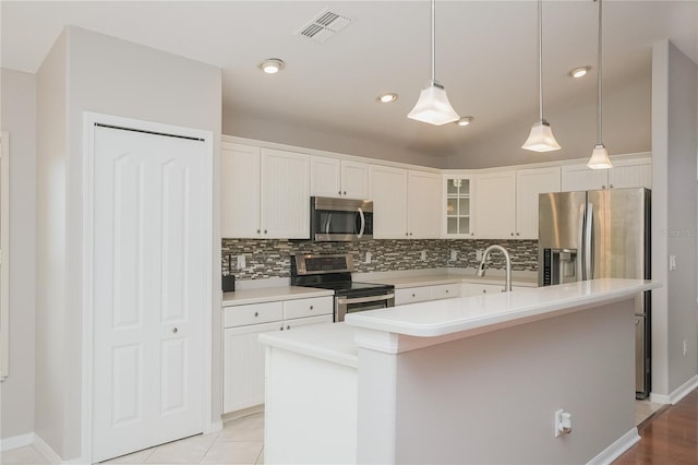 11741 Teapot Ct, Spring Hill, FL 34609 - kitchen with appliances with stainless steel finishes, tasteful backsplash, a center island with sink, glass insert cabinets, and recessed lighting