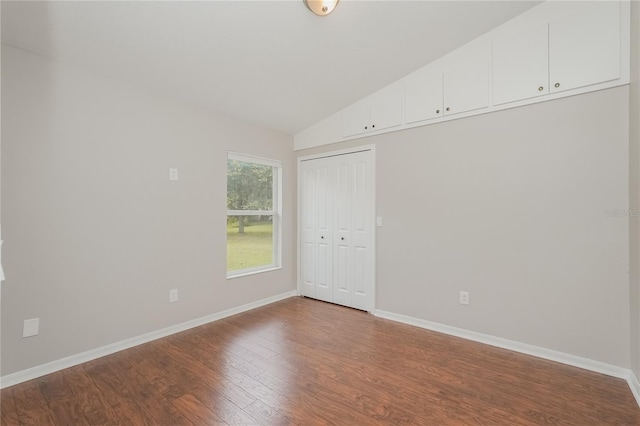 11741 Teapot Ct, Spring Hill, FL 34609 - unfurnished bedroom featuring dark wood-style floors, vaulted ceiling, baseboards, and a closet