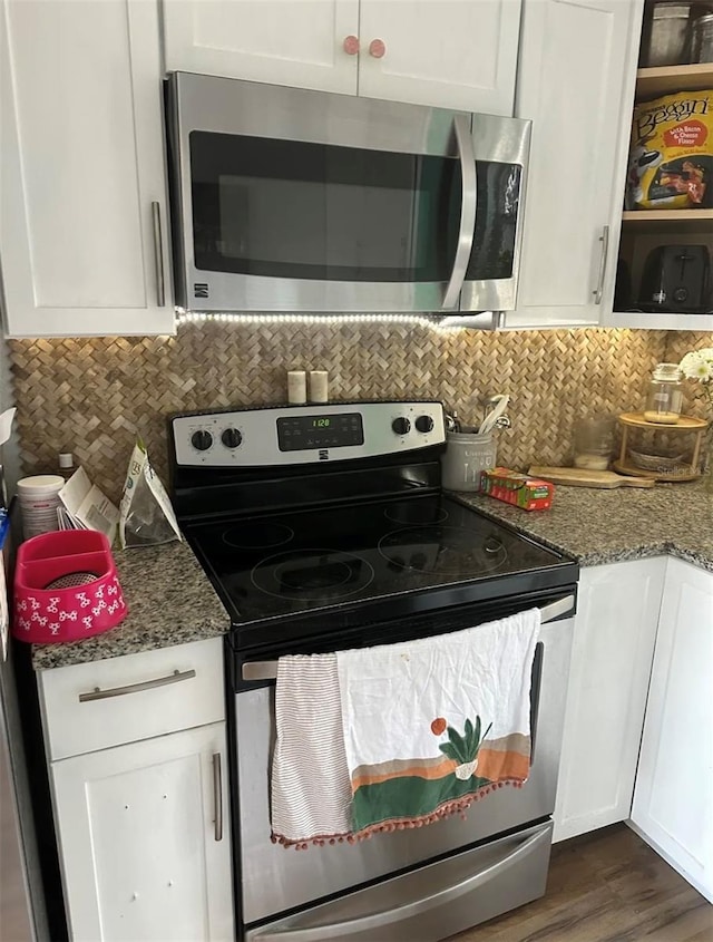 6741 4th Ave N, Saint Petersburg, FL 33710 - kitchen with stainless steel appliances, white cabinetry, tasteful backsplash, and light stone countertops
