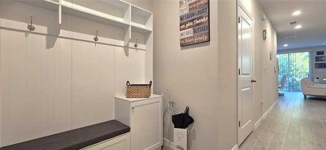 mudroom with light wood-style floors, baseboards, and recessed lighting