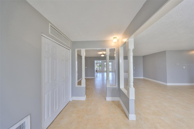 710 116th Ave, Treasure Island, FL 33706 - hall featuring decorative columns, baseboards, and light tile patterned flooring
