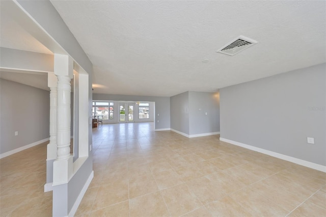 710 116th Ave, Treasure Island, FL 33706 - unfurnished room with light tile patterned floors, a textured ceiling, and baseboards