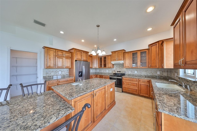 710 116th Ave, Treasure Island, FL 33706 - kitchen with appliances with stainless steel finishes, a sink, brown cabinetry, and recessed lighting