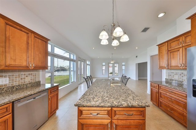 710 116th Ave, Treasure Island, FL 33706 - kitchen featuring stainless steel appliances, a chandelier, brown cabinetry, backsplash, and recessed lighting